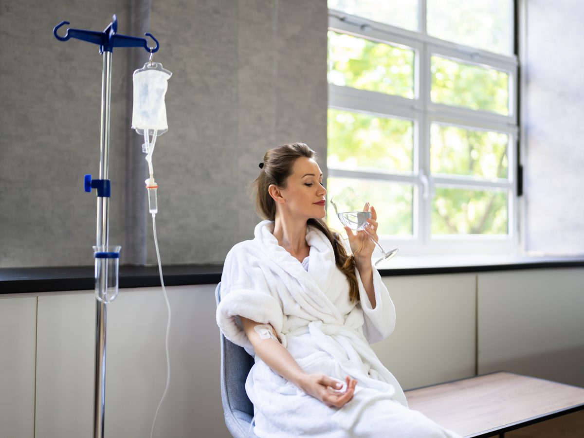 Paciente confortável recebendo soroterapia endovenosa em ambiente de clínica